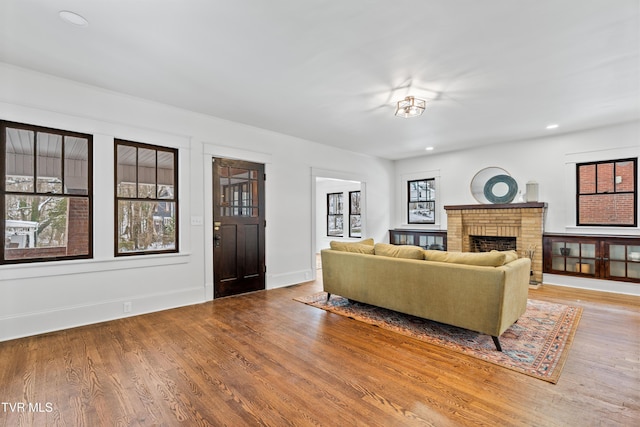 living room with a fireplace and light wood-type flooring