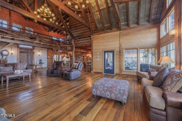 living room with an inviting chandelier, beamed ceiling, hardwood / wood-style flooring, wood walls, and high vaulted ceiling