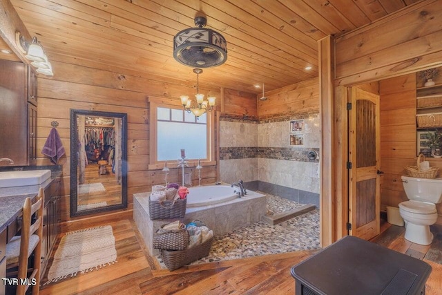 bathroom featuring a relaxing tiled tub, hardwood / wood-style floors, toilet, a chandelier, and wood ceiling