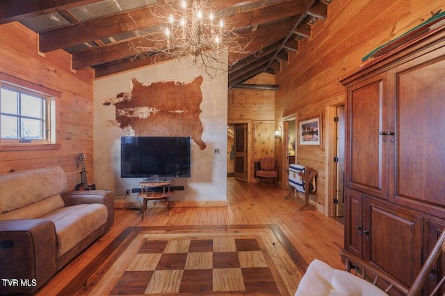 living room featuring wooden walls, a chandelier, hardwood / wood-style floors, and vaulted ceiling with beams