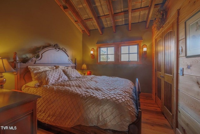 bedroom with hardwood / wood-style flooring, wood ceiling, and vaulted ceiling with beams