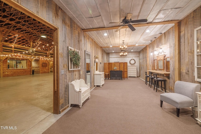 interior space with wooden walls, light carpet, ceiling fan, and wood ceiling