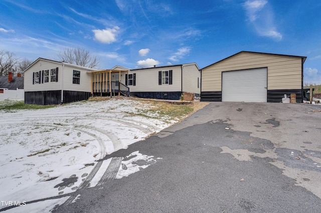 manufactured / mobile home featuring driveway, a detached garage, and an outdoor structure