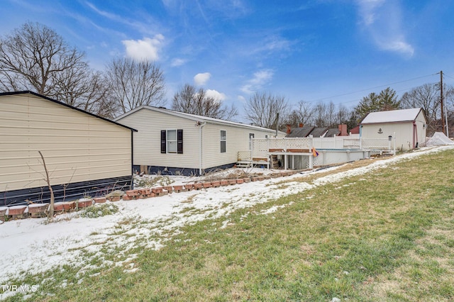 snow covered house featuring an outbuilding, a fenced in pool, and a lawn