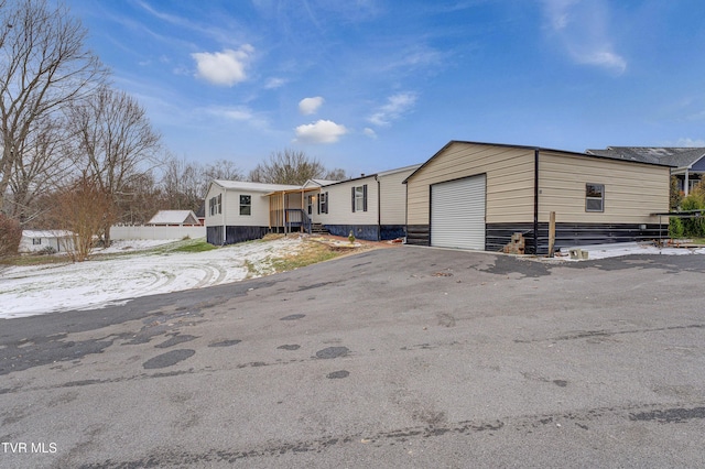 manufactured / mobile home featuring an outdoor structure, a garage, and aphalt driveway