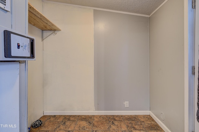 washroom featuring ornamental molding, stone finish flooring, baseboards, and a textured ceiling