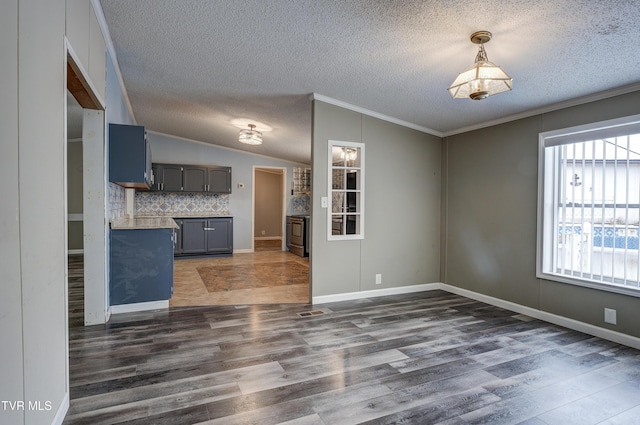 interior space with dark wood finished floors, a textured ceiling, crown molding, and vaulted ceiling