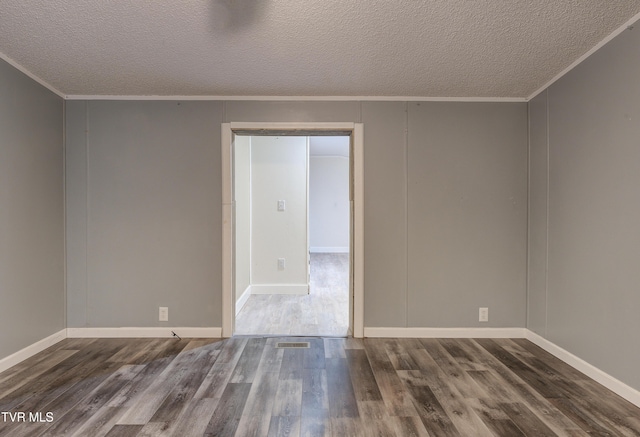 unfurnished room featuring a textured ceiling, crown molding, and wood finished floors