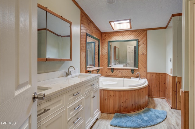 bathroom featuring wood finished floors, a skylight, ornamental molding, wood walls, and a textured ceiling