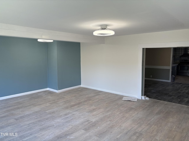 empty room featuring baseboards and wood finished floors