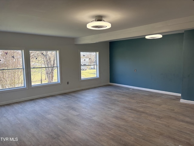 spare room with dark wood finished floors and baseboards