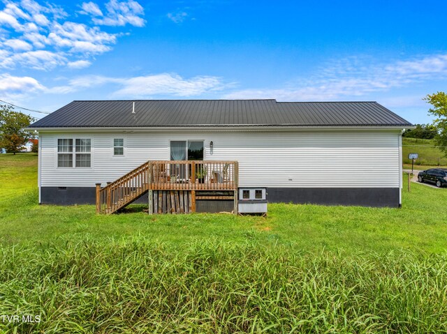 back of house with a lawn and a deck