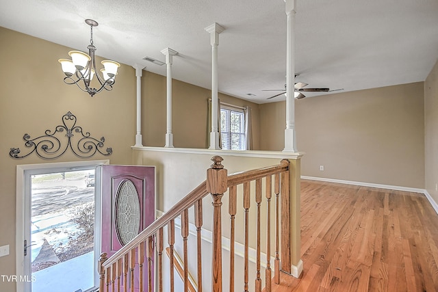 corridor featuring a textured ceiling, an inviting chandelier, and hardwood / wood-style flooring