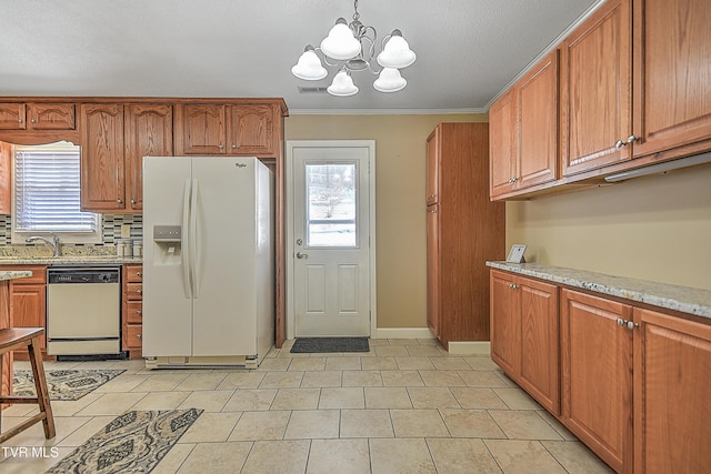 kitchen featuring decorative light fixtures, a healthy amount of sunlight, dishwashing machine, a notable chandelier, and white fridge with ice dispenser