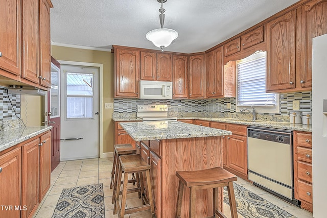 kitchen featuring dishwasher, a kitchen bar, light stone counters, a kitchen island, and range with electric stovetop