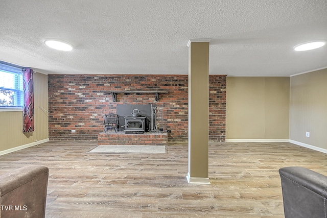 unfurnished living room with hardwood / wood-style flooring, a textured ceiling, and a wood stove