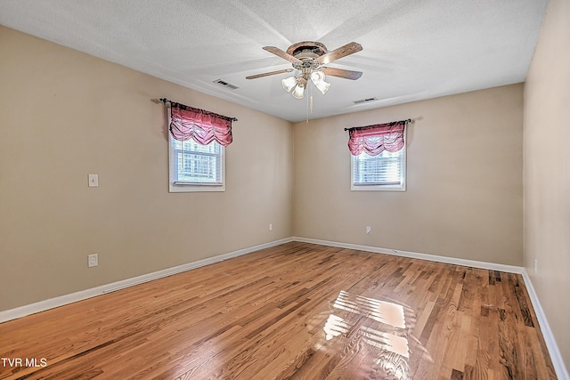 unfurnished room with ceiling fan, hardwood / wood-style floors, and a textured ceiling