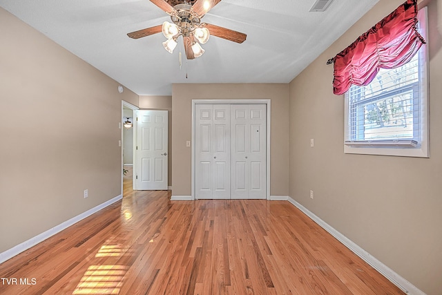 unfurnished bedroom featuring ceiling fan, a closet, and light hardwood / wood-style floors