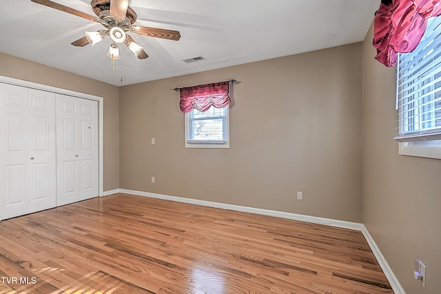 unfurnished bedroom with a closet, ceiling fan, and wood-type flooring