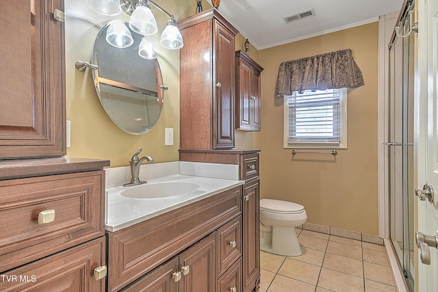 bathroom with toilet, tile patterned flooring, a shower with door, ornamental molding, and vanity