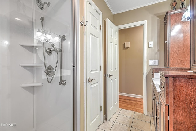 bathroom with tile patterned flooring, a shower with shower door, and ornamental molding