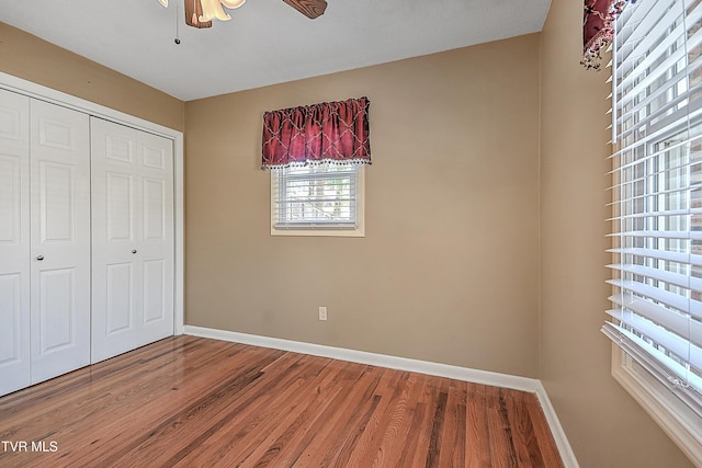 unfurnished bedroom with ceiling fan, a closet, and hardwood / wood-style flooring