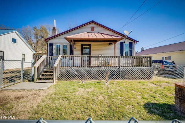 bungalow featuring metal roof, a standing seam roof, a gate, fence, and a front lawn