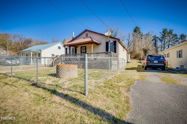 bungalow-style house featuring driveway, a front lawn, and fence