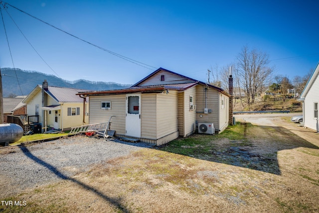 rear view of property featuring metal roof, ac unit, and a mountain view