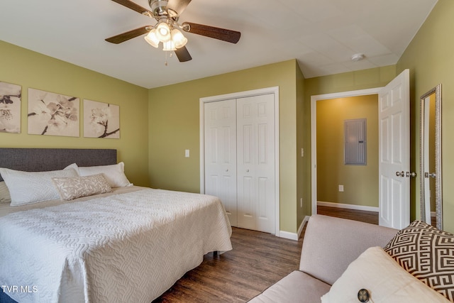 bedroom featuring dark wood-type flooring, ceiling fan, electric panel, and a closet