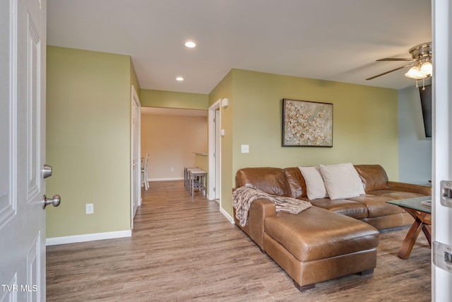 living room featuring ceiling fan and light hardwood / wood-style flooring