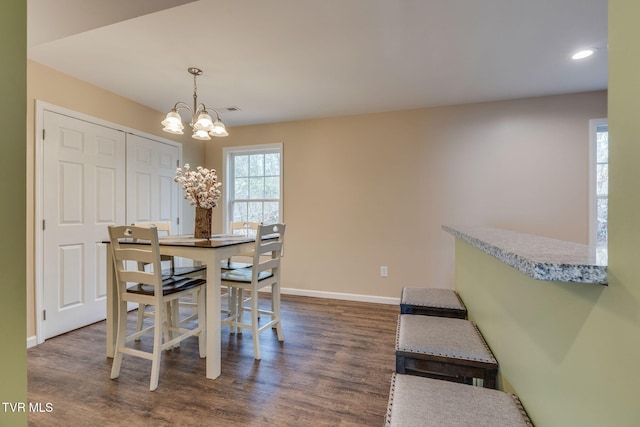 dining area with dark wood-type flooring and a chandelier