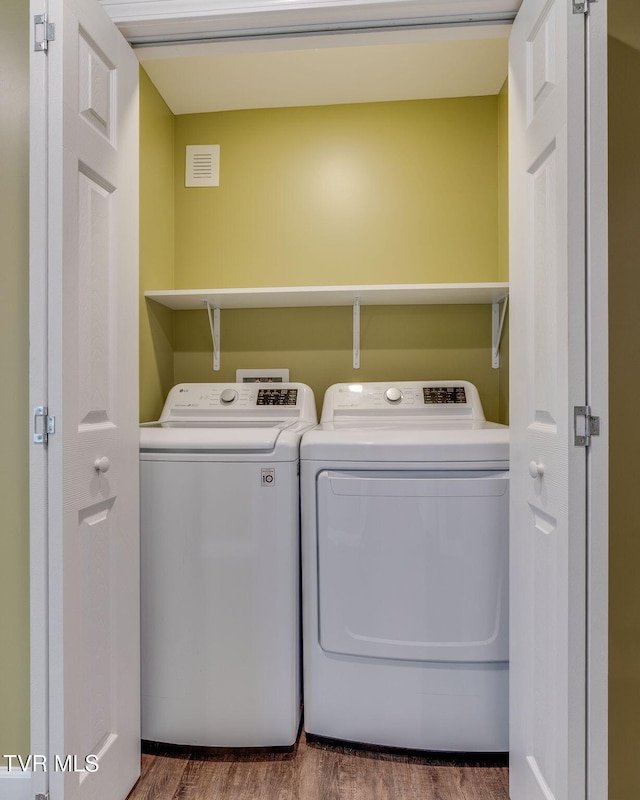 washroom with dark wood-type flooring and independent washer and dryer