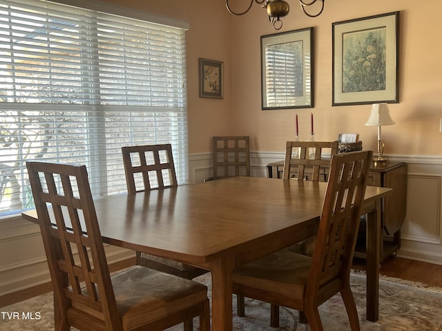 dining area featuring a wainscoted wall, a decorative wall, and a wealth of natural light