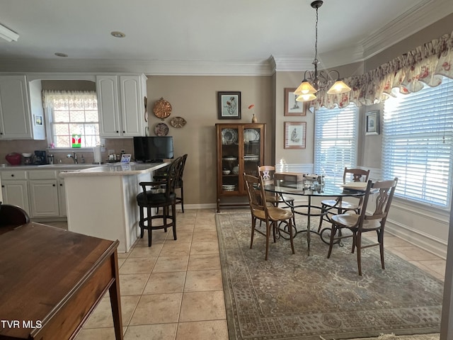 dining room featuring light tile patterned floors, baseboards, ornamental molding, and a notable chandelier