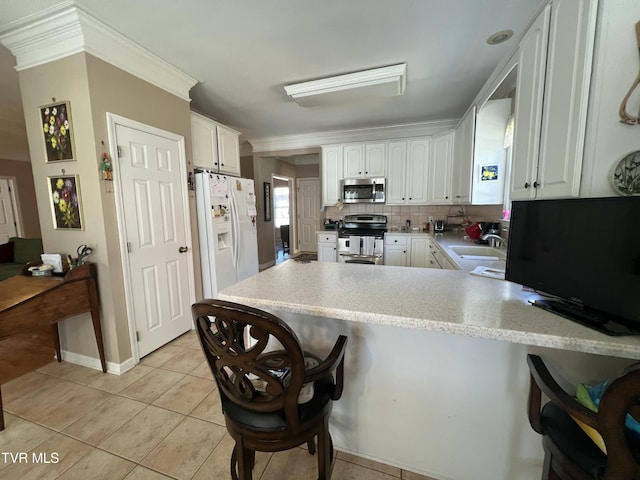 kitchen with a peninsula, white cabinetry, appliances with stainless steel finishes, and light countertops