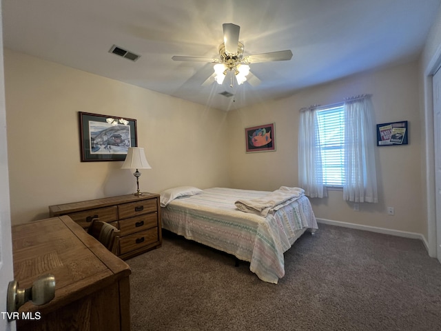 bedroom featuring a ceiling fan, dark carpet, visible vents, and baseboards