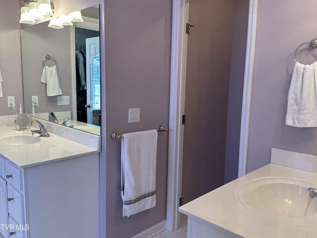 bathroom with a walk in closet and vanity