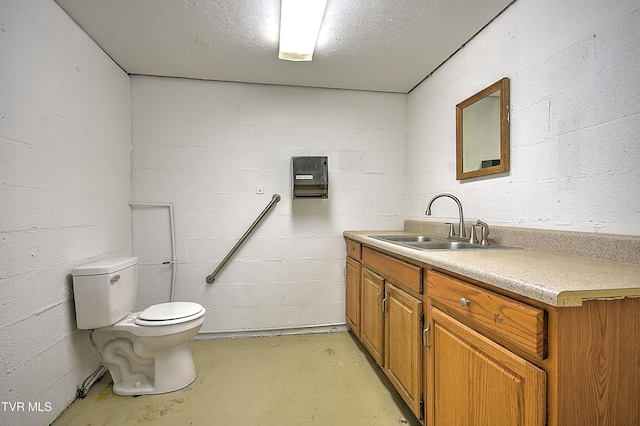 bathroom featuring toilet, vanity, a textured ceiling, and concrete flooring