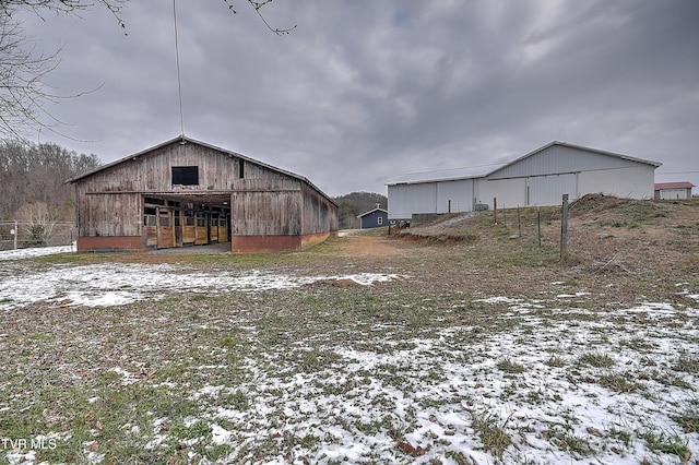 yard covered in snow with an outbuilding