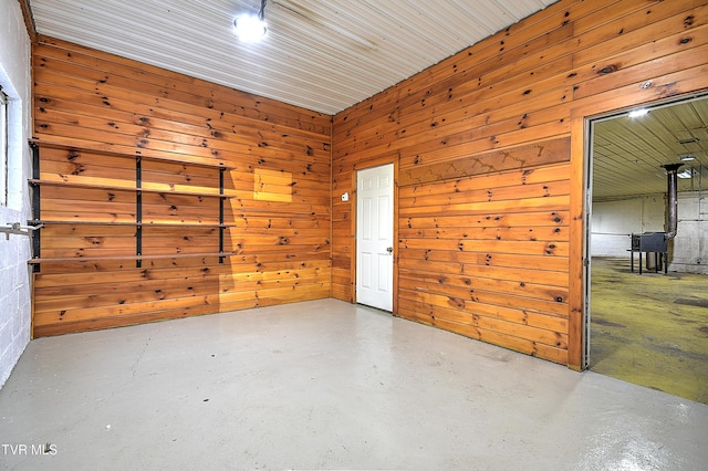 unfurnished room with concrete flooring and wood walls