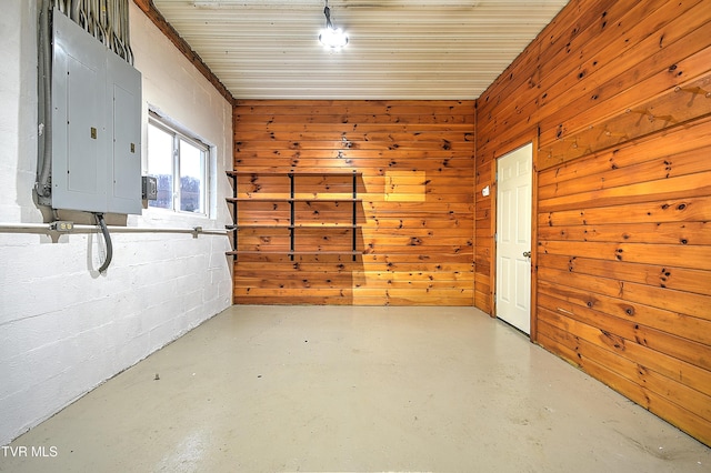 basement featuring wood walls and electric panel