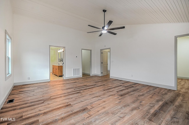 unfurnished bedroom featuring ceiling fan, ensuite bathroom, hardwood / wood-style flooring, and high vaulted ceiling