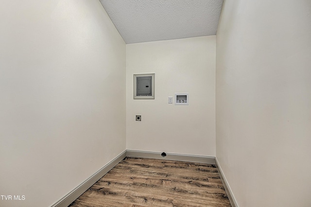 washroom with a textured ceiling, wood-type flooring, washer hookup, hookup for an electric dryer, and electric panel