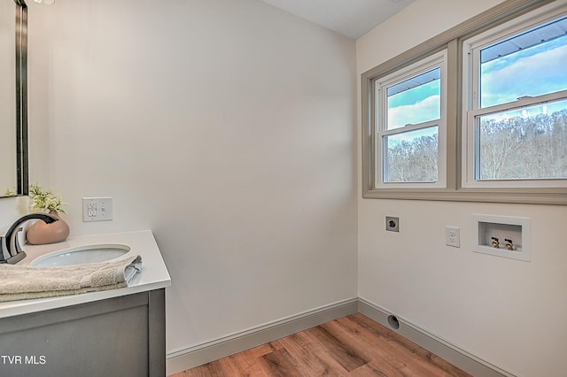 washroom featuring sink, light hardwood / wood-style floors, hookup for a washing machine, and electric dryer hookup