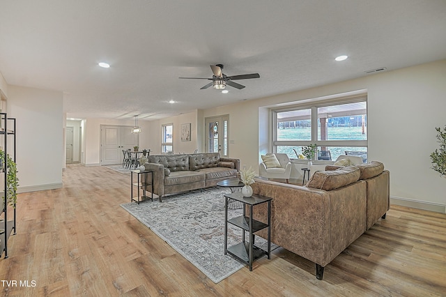 living room with ceiling fan and light hardwood / wood-style floors