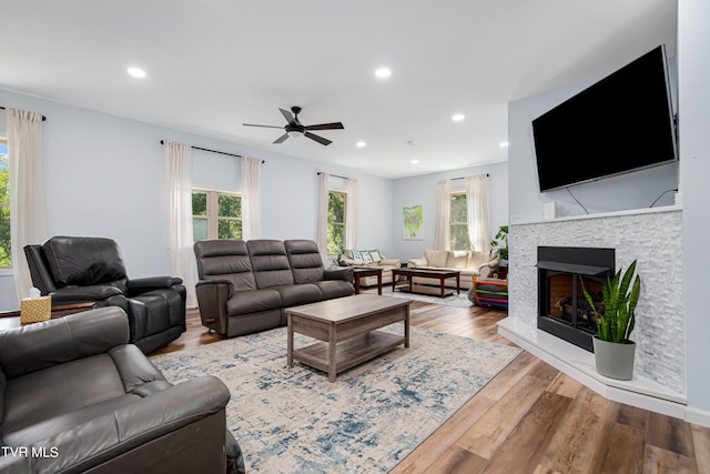 living room featuring light hardwood / wood-style floors, ceiling fan, and a wealth of natural light