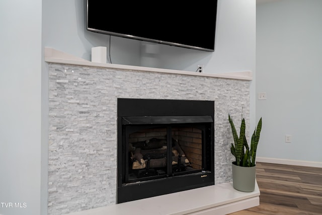 room details featuring hardwood / wood-style floors and a stone fireplace