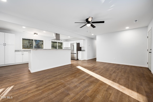 unfurnished living room featuring ceiling fan, dark wood-type flooring, and sink