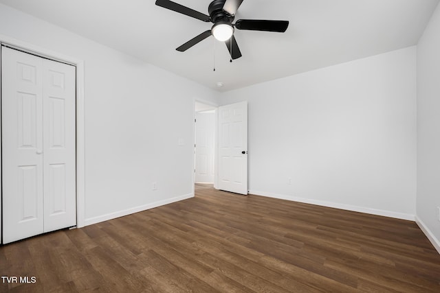 unfurnished bedroom featuring dark wood-type flooring, ceiling fan, and a closet